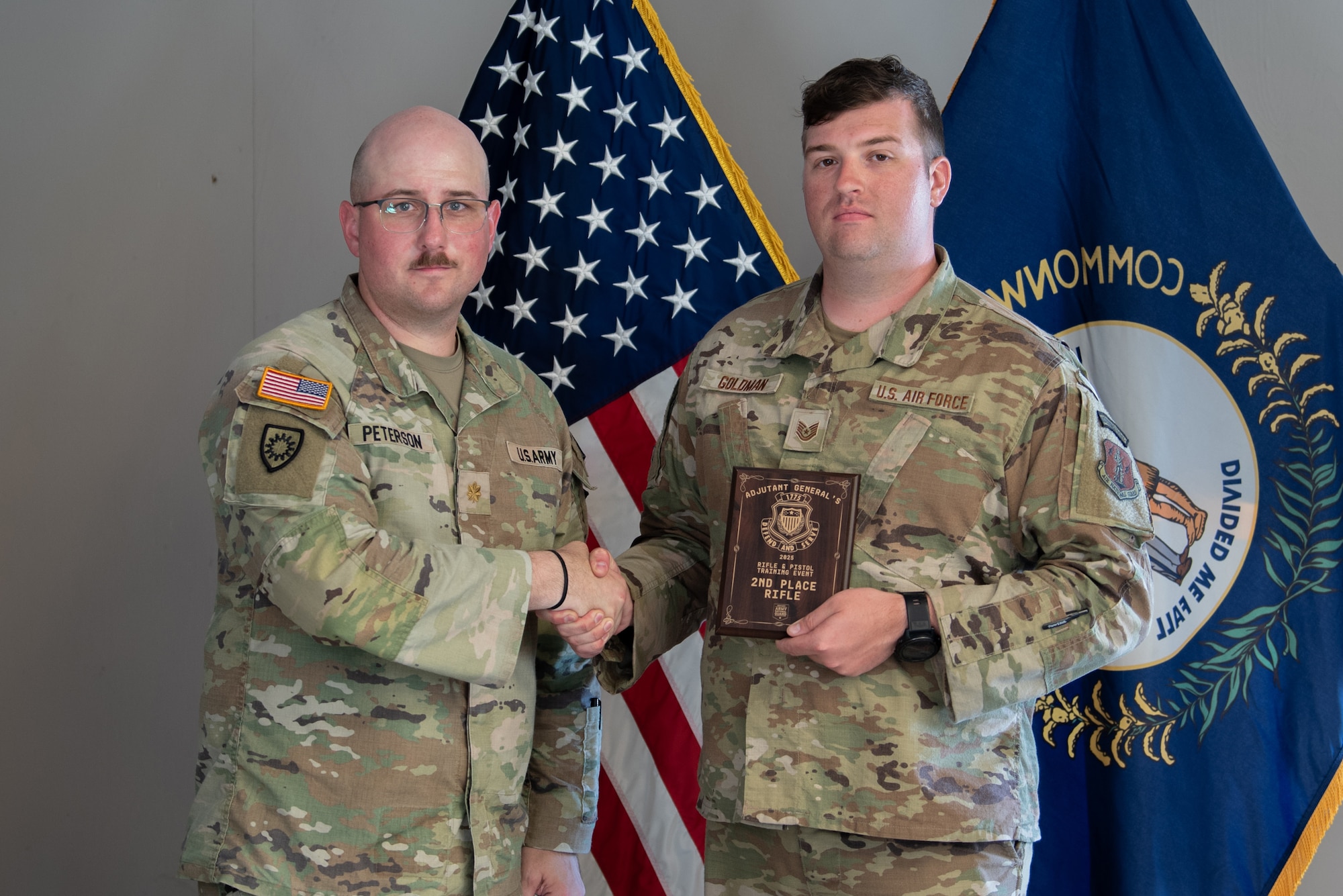 U.S. Army Maj. Christopher Peterson, left, state marksmanship coordinator for the Kentucky Army National Guard, presents U.S. Air Force Tech. Sgt. Austin Goldman of the Kentucky Air National Guard’s 123rd Contingency Response Group with the second-place rifle award July 13, 2025, at the conclusion of the Adjutant General’s Match, a marksmanship competition held at the Wendell H. Ford Regional Training center in Greenville, Ky. The event tested Soldiers and Airmen with realistic, combat-focused shooting scenarios designed to sharpen weapons proficiency and lethality. (U.S. Air National Guard photo by Airman 1st Class Angelee Barnett)