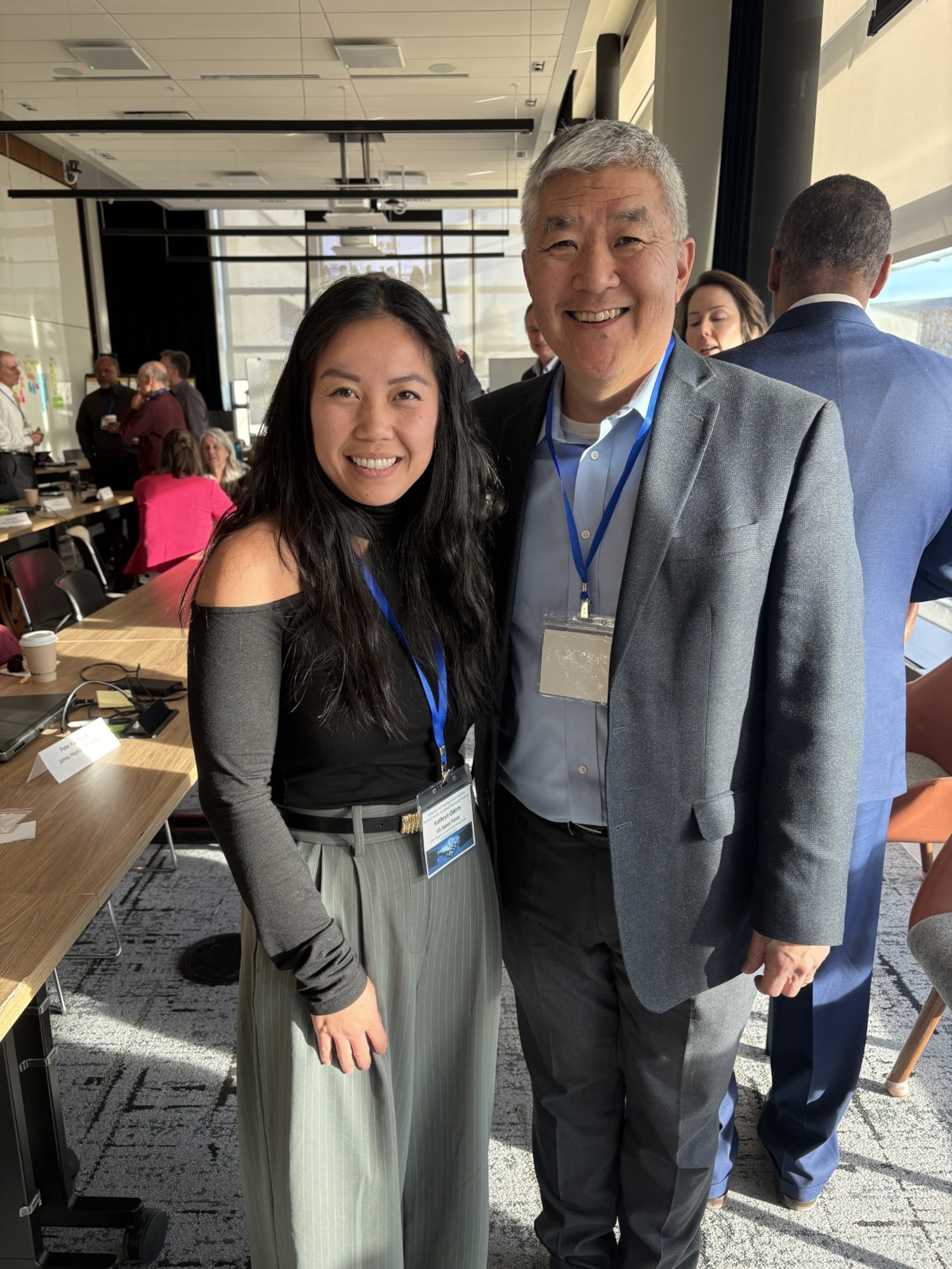 Woman and man in business casual dress smile together in a conference room