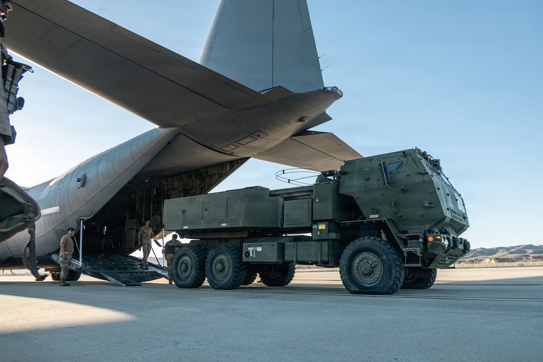 A U.S. Marine Corps M142 High Mobility Artillery Rocket System assigned to Tango Battery, 1st Battalion, 11th Marine Regiment, 1st Marine Division, loads into a U.S. Air Force C-130J Super Hercules assigned to 39th Airlift Squadron, 317th Operations Group, 317th Airlift Wing during Exercise Steel Knight 25 at Marine Corps Base Camp Pendleton, California, Dec. 10, 2025. Steel Knight is an annual exercise that strengthens the Navy-Marine Corps team's ability to respond forward, integrate across domains, and sustain Marine Air-Ground Task Force readiness. (U.S. Marine Corps photo by Cpl. Anita Ramos)