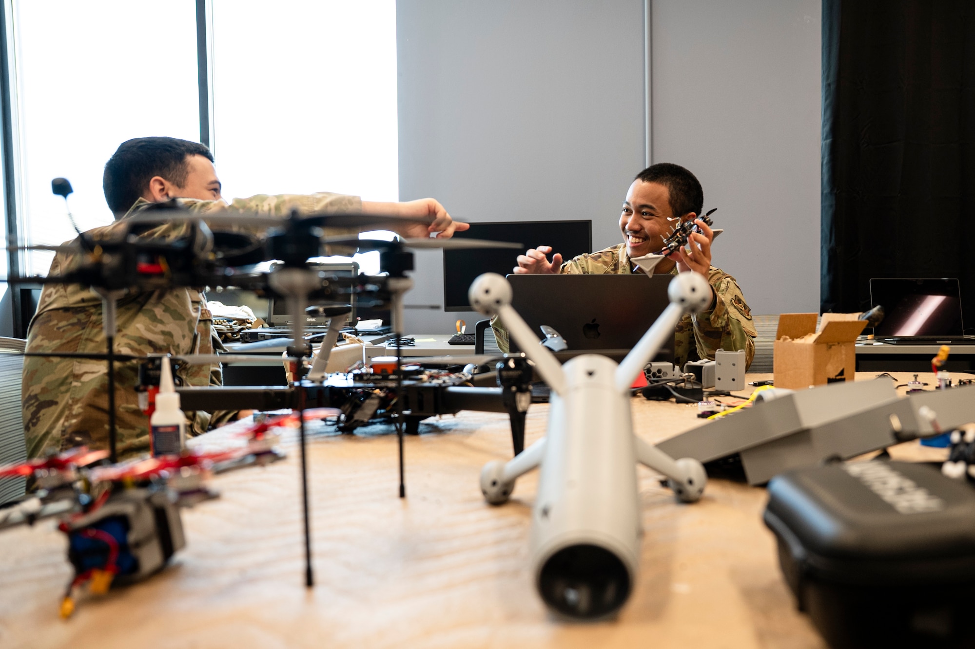 People in military uniform inspect drones