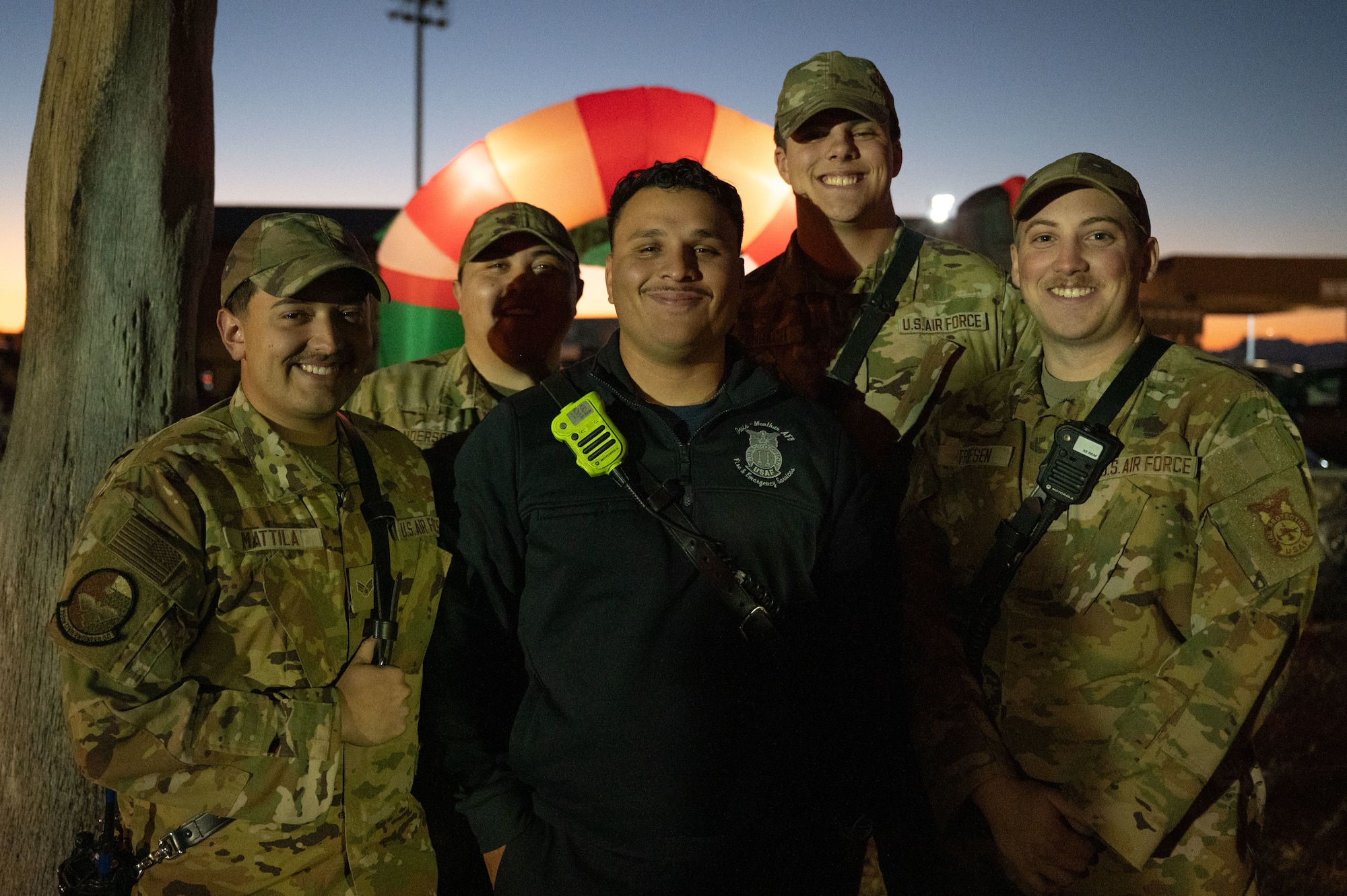U.S. Air Force Airmen assigned to the 355th Civil Engineer Squadron Fire Department gather during the 2025 Christmas Tree Lighting at Davis-Monthan Air Force Base, Arizona, Dec. 5, 2025. The event provided an opportunity for base families to celebrate the beginning of the holiday season. (U.S. Air Force photo by Airman 1st Class Jaden Kidd)