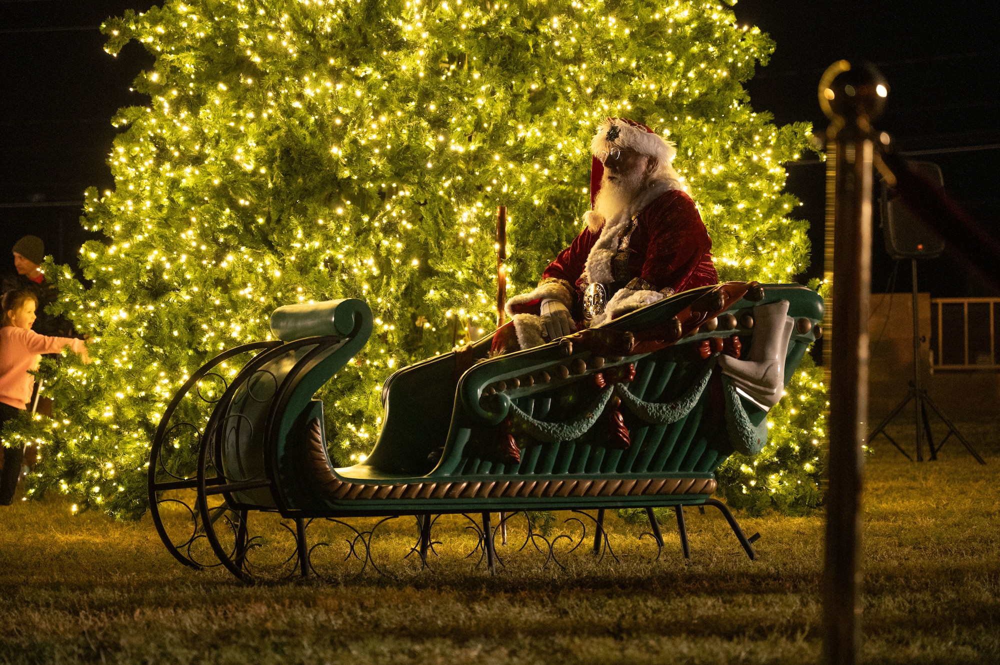 Santa Claus sits in his sleigh during the 2025 Christmas Tree Lighting at Davis-Monthan Air Force Base, Arizona, Dec. 5, 2025. The annual event brought Airmen and their families together to celebrate the holiday season. (U.S. Air Force photo by Airman 1st Class Jaden Kidd)