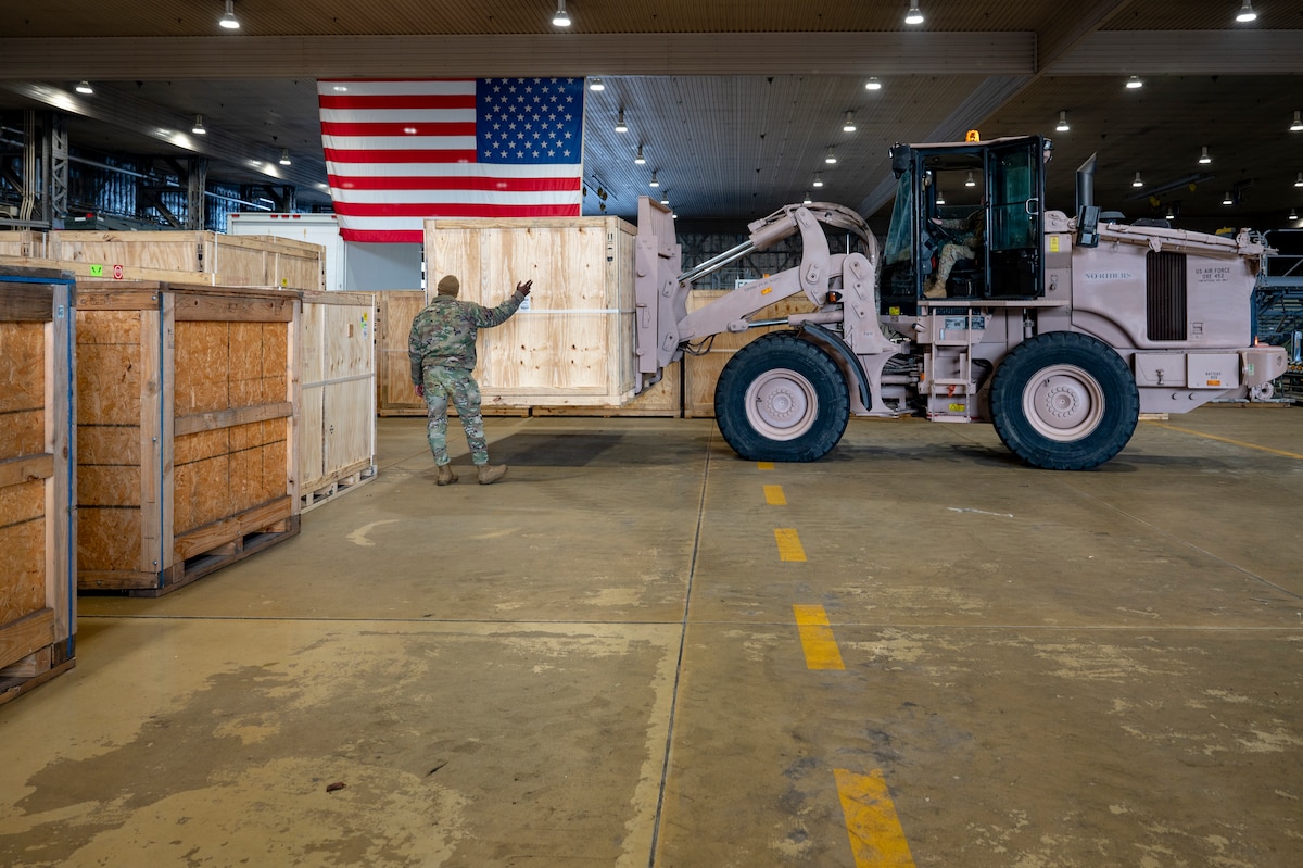 U.S. Air Force Staff Sgt. Ardo Dia, 13th Fighter Generation Squadron support supervisor, guides Senior Airman Matthew Cline, 13th Fighter Generation Squadron weapons loadcrew member, as he delivers cargo on a forklift at Misawa Air Base, Japan, Dec. 15, 2025. Misawa AB received F-35 Lightning II equipment in preparation for their arrival, strengthening the 35th Fighter Wing’s readiness to generate and employ advanced airpower capabilities. (U.S. Air Force photo by Senior Airman Brittany Russell)