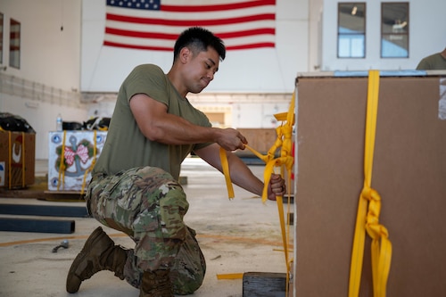 U.S. Air Force Senior Airman Joshua Gakud, 374th Air Expeditionary Wing combat mobility flight combat mobility technician, secures a bundle.