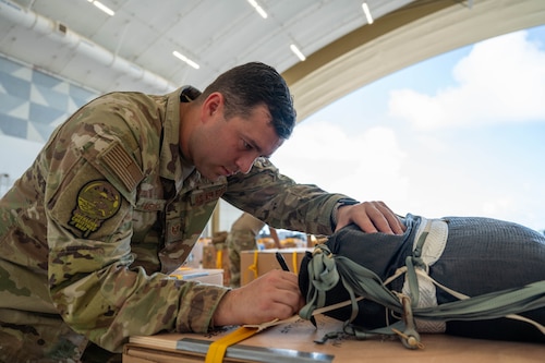 U.S. Air Force Staff Sgt. Edwin Melón, 374th Air Expeditionary Wing combat mobility flight  team lead, marks a completed humanitarian assistance bundle.