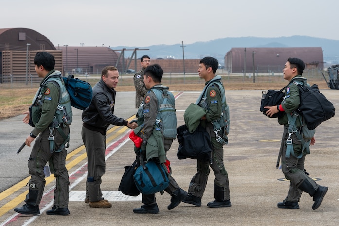 A U.S. Air Force pilot shakes hands with Republic of Korea Air Force pilots.