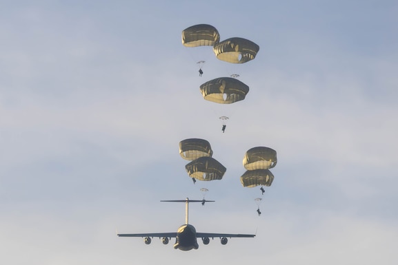 U.S. Army Soldiers of the 2nd Infantry Brigade Combat Team (IBCT)(Airborne), 11th Airborne Division,  jump out of an Air Force C-17 above Pohakuloa Training Area, Hawaii, Nov. 5, 2025. The IBCT launched from Joint Base Elmendorf-Richardson, demonstrating its capability to deploy rapidly anywhere in the Pacific.