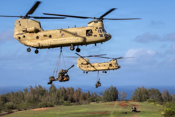 Two CH-47 Chinook Helicopters assigned to the 3rd Battalion, 25th Aviation Regiment, 25th Combat Aviation Brigade sling load M119 Howitzers during air assault operations at Kahuku Training Area (KTA), Hawaii on November 14, 2025.