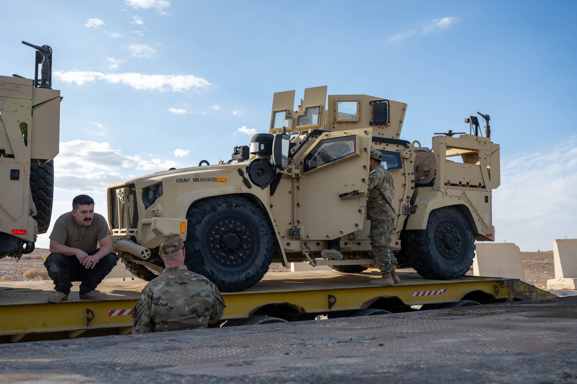 U.S. Airmen prepare to offload a Joint Light Tactical Vehicle from a delivery truck in the U.S. Central Command area of responsibility, Dec. 2, 2025. The JLTV is equipped with structural upgrades, including a new drive shaft and self inflating tires, to better perform in a variety of situations. (U.S. Air Force photo by Senior Airman Kari Degraffenreed)