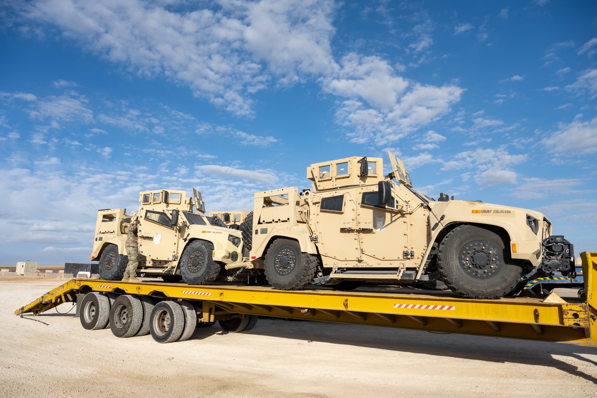 Two Joint Light Tactical Vehicles sit on a delivery truck in the U.S. Central Command area of responsibility, Dec. 2, 2025. The 332nd ELRS delivered a group of new JLTVs to the installation, which innovate over the past model with survivability and internal electronic upgrades. (U.S. Air Force photo by Senior Airman Kari Degraffenreed)