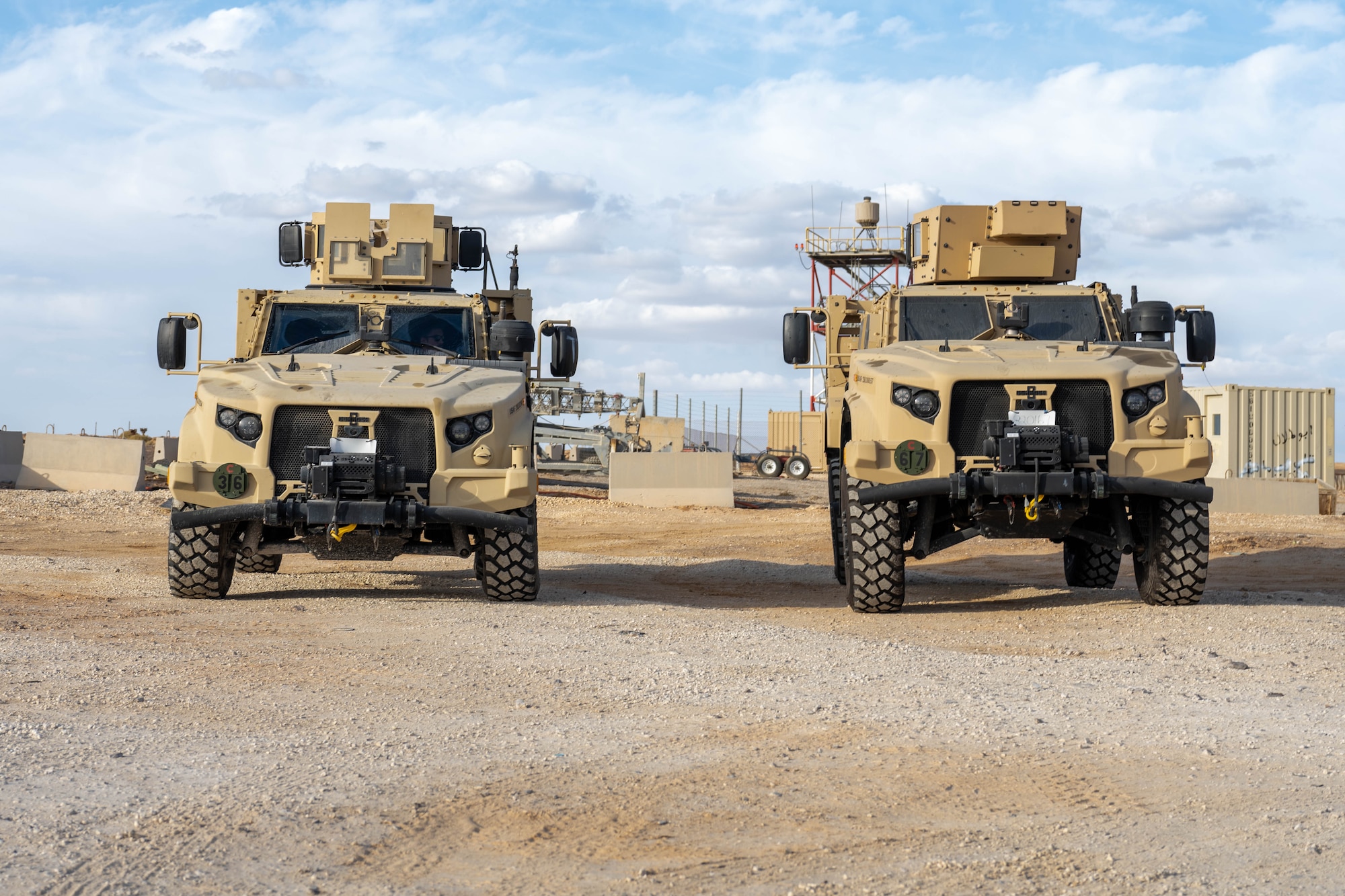 Two Joint Light Tactical Vehicles assigned to the 332nd Air Expeditionary Wing sit in the U.S. Central Command area of responsibility, Dec. 2, 2025. The 332nd ELRS delivered a group of new JLTVs to the installation, which innovate over the past model with survivability and internal electronic upgrades. (U.S. Air Force photo by Senior Airman Kari Degraffenreed)