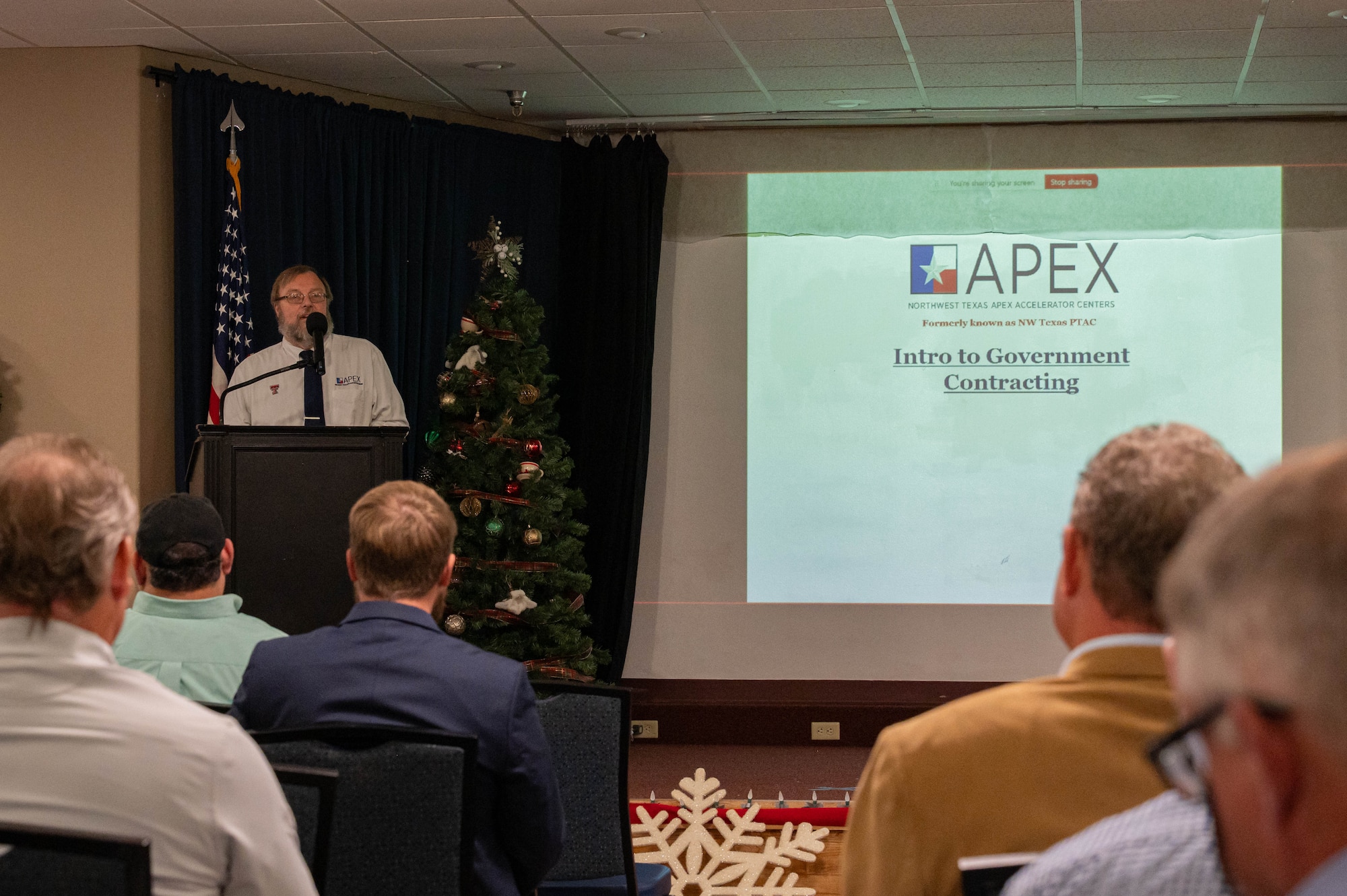 Richard Lyles, director of Northwest Texas APEX Accelerators, discusses federal contracting assistance with contractors during the B-21 Industry Day at Dyess Air Force Base, Texas, Dec. 12, 2025. During the event, attendees received briefings on contracting requirements, project timelines and expectations for major construction projects as part of a long-term modernization plan to prepare Dyess for the B-21 Raider while sustaining ongoing B-1B Lancer and C-130J Super Hercules operations. (U.S. Air Force photo by Airman William Neal)