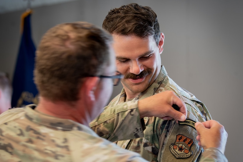 U.S. Air Force Tech. Sgt. Nicholas Miller of the Kentucky Air National Guard’s 123rd Contingency Response Group, receives the Governor’s Twenty Tab on July 13, 2025, from U.S. Army Sgt. 1st Class Edward Cole, senior marksmanship coordinator for the Kentucky Army National Guard Small Arms Readiness Training Section, following the Adjutant General’s Match, a marksmanship competition held at the Wendell H. Ford Regional Training center in Greenville, Ky. The tab recognizes marksmen who finish in the top 20 percent of all competitors. (U.S. Air National Guard photo by Airman 1st Class Angelee Barnett)