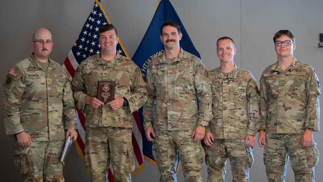 U.S. Army Maj. Christopher Peterson, left, state marksmanship coordinator for the Kentucky Army National Guard, presents the third-place overall award to members of the Kentucky Air National Guard Marksmanship Team July 13, 2025, at the conclusion of the Adjutant General’s Match, a marksmanship competition held at the Wendell H. Ford Regional Training center in Greenville, Ky. The event tested Soldiers and Airmen with realistic, combat-focused shooting scenarios designed to sharpen weapons proficiency and lethality. (U.S. Air National Guard photo by Airman 1st Class Angelee Barnett)
