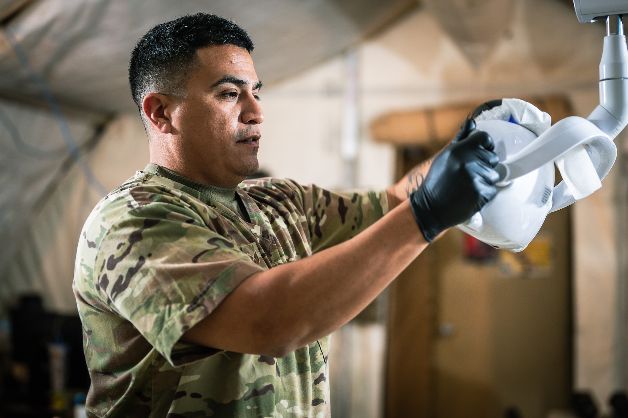 U.S. Staff Sgt. Miguel Guajardo, 378th EMDS dental clinic non-commissioned officer in charge, cleans a dental light