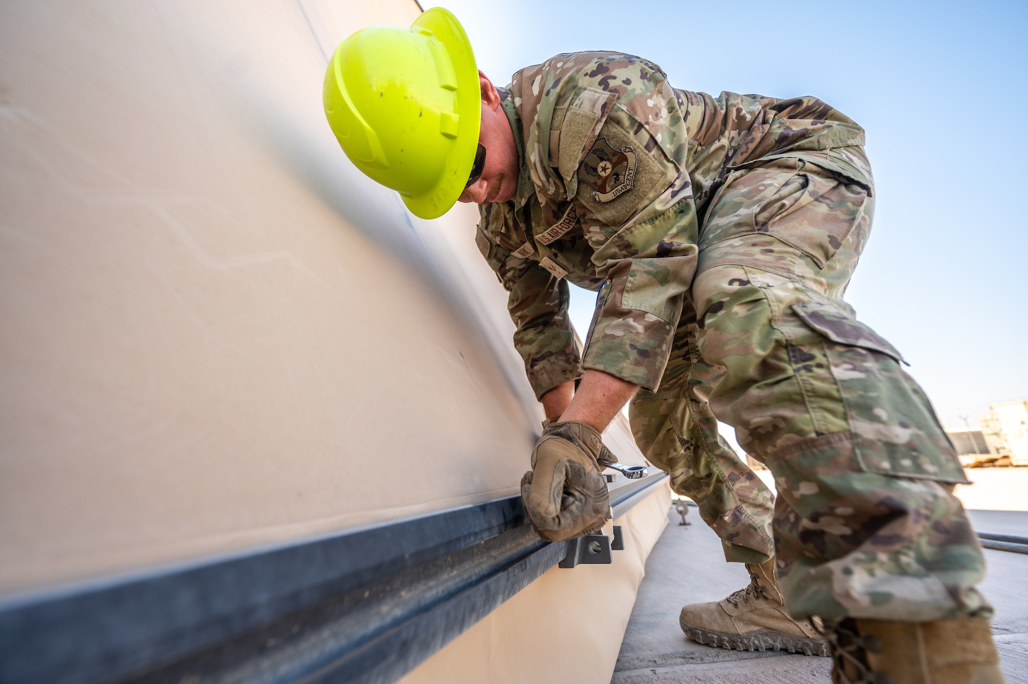 U.S. Air Force Senior Airman Austin Kirk, and Airman 1st Class Sean Stark, 378th Expeditionary Civil Engineer Squadron structural maintenance journeymen, inspect tension fabric systems on large area maintenance shelters
