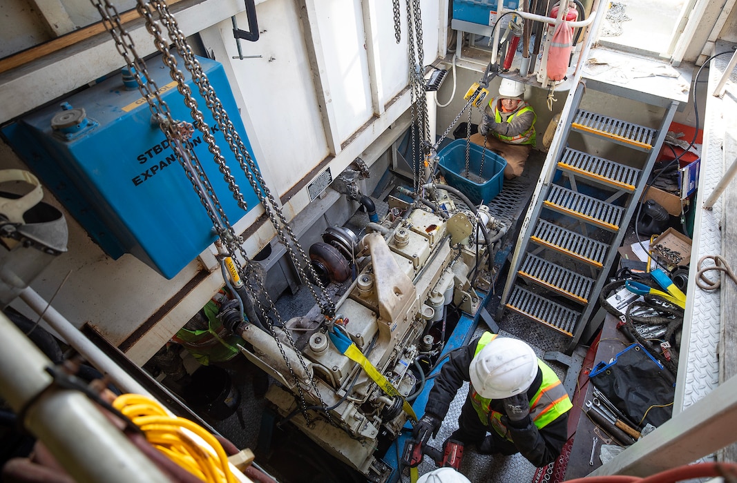 A photo of eingines being removed from a towboat.
