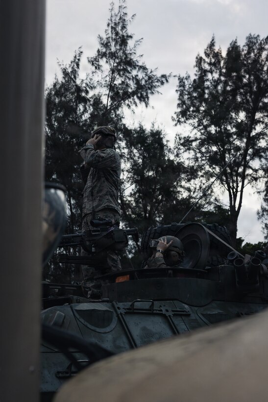 U.S. Marines with Weapons Company, Battalion Landing Team 3rd Battalion, 1st Marine Regiment, 31st Marine Expeditionary Unit, conduct a communication check during a simulated tactical recovery of aircraft personnel exercise as part of MEU Exercise at Camp Schwab, Okinawa, Japan, Dec. 10, 2025. The simulated TRAP exercise showcased advanced trauma life support capabilities and evaluated the platoon’s rapid response and recovery tactics of downed aircraft, personnel and equipment in isolated locations. The 31st MEU, the Marine Corps’ only continuously forward deployed MEU, provides a flexible and lethal force, ready to perform a wide range of military operations as the premiere crisis response force in the Indo-Pacific region. (U.S. Marine Corps photo by Sgt. Alora Finigan)