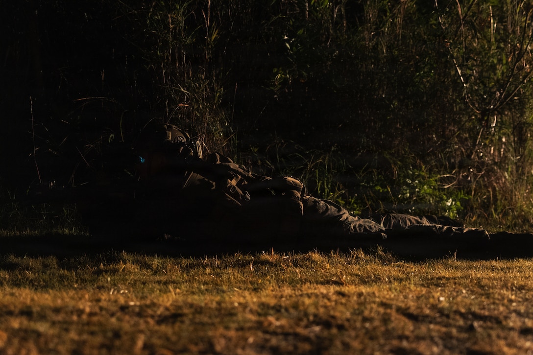 A U.S. Marine with Weapons Company, Battalion Landing Team 3rd Battalion, 1st Marine Regiment, 31st Marine Expeditionary Unit, sets security during a simulated tactical recovery of aircraft personnel exercise as part of MEU Exercise at Camp Schwab, Okinawa, Japan, Dec. 10, 2025. The simulated TRAP exercise showcased advanced trauma life support capabilities and evaluated the platoon’s rapid response and recovery tactics of downed aircraft, personnel and equipment in isolated locations. The 31st MEU, the Marine Corps’ only continuously forward deployed MEU, provides a flexible and lethal force, ready to perform a wide range of military operations as the premiere crisis response force in the Indo-Pacific region. (U.S. Marine Corps photo by Sgt. Alora Finigan)