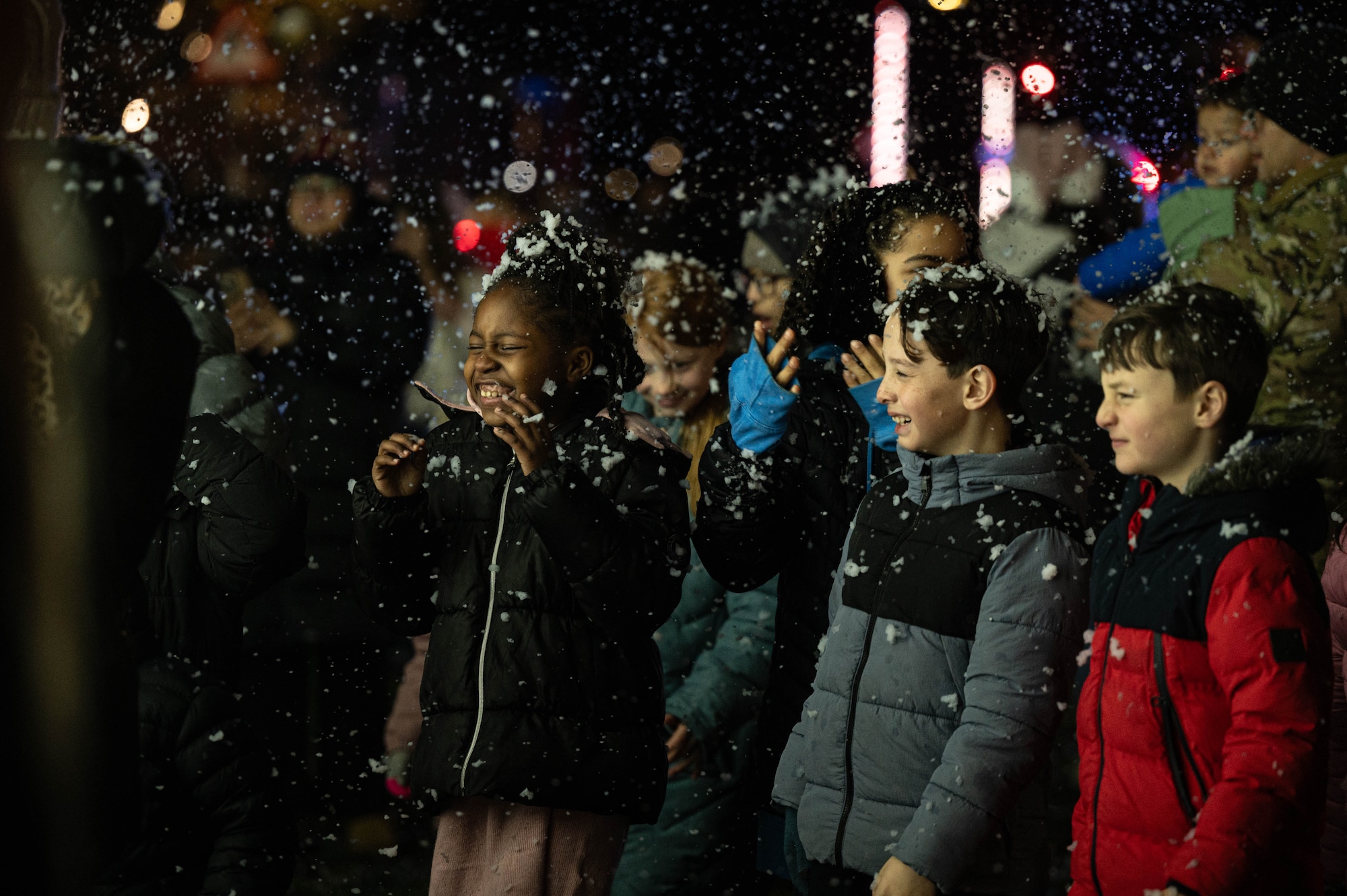 children laugh and smile as snow falls on their heads