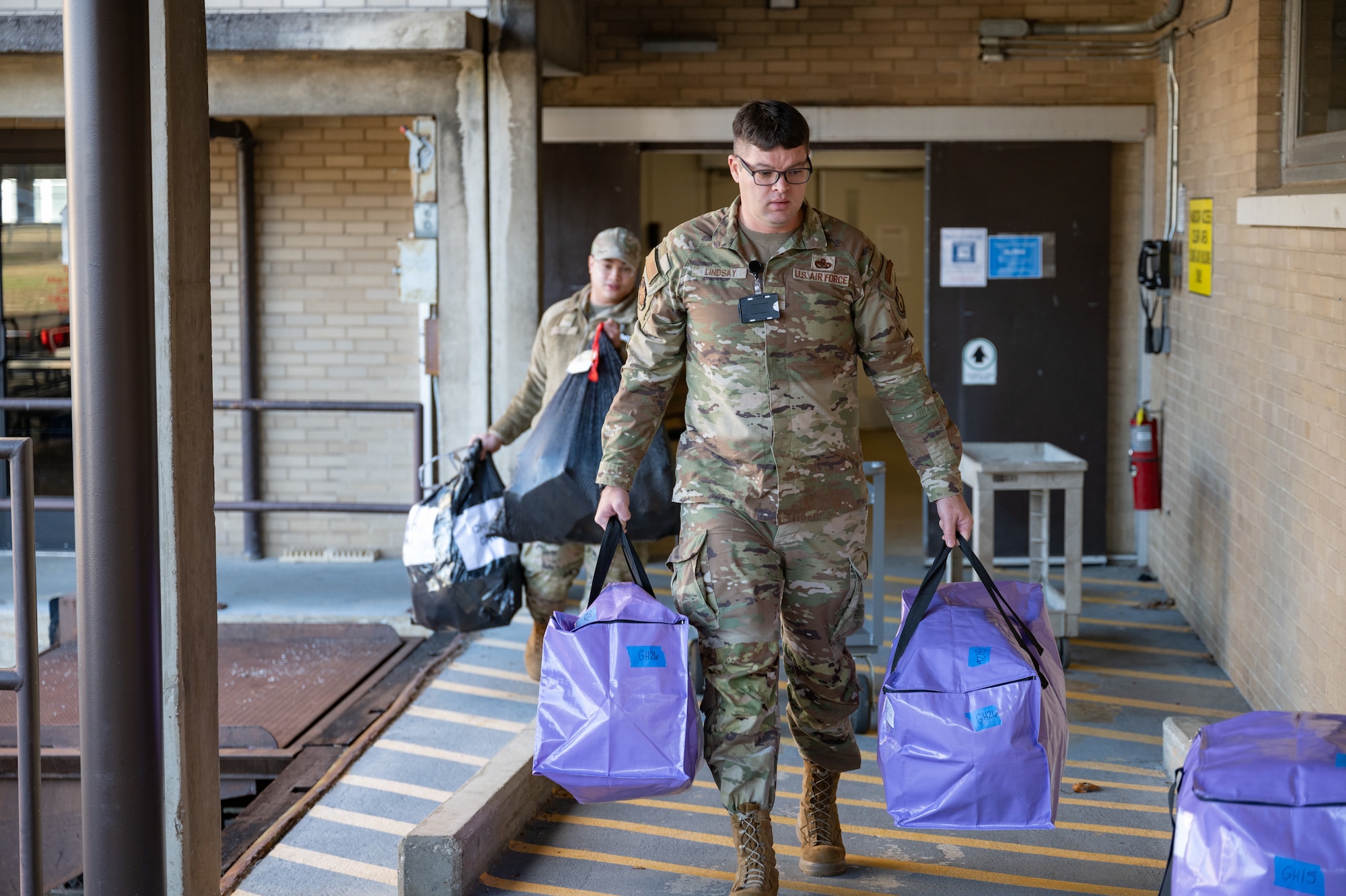 2nd Lt. James Lindsay carries for pickup by a local charity some of the items purchased by Arnold AFB team members through the Project Christmas program. This year, 105 children were sponsored and will receive gifts from Arnold personnel. (U.S. Air Force photo by Keith Thornburgh)