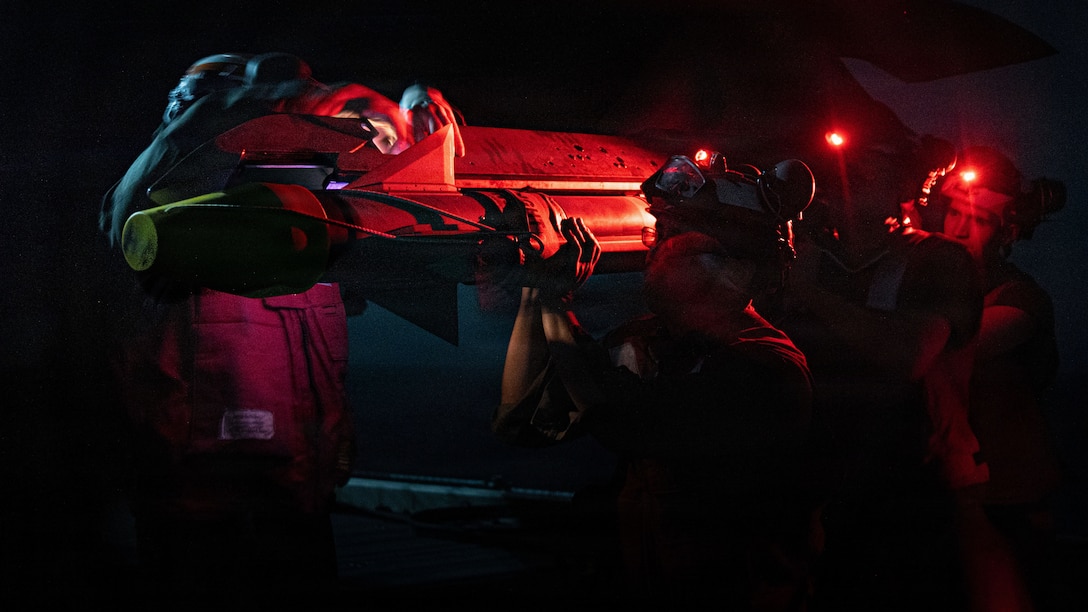 U.S. Marines with Marine Fighter Attack Squadron (VMFA) 242, 31st Marine Expeditionary Unit, prepare to load ordinance onto an F-35B Lightning II aboard the forward-deployed amphibious assault carrier USS Tripoli (LHA 7), flagship of the Tripoli Expeditionary Strike Group, Dec. 7, 2025, while conducting routine operations in the U.S. 7th Fleet Area of Operations. The 31st MEU, the Marine Corps’ only continuously forward-deployed MEU, provides a flexible and lethal force ready to perform a wide range of military operations as the premiere crisis response force in the Indo-Pacific region. (U.S. Marine Corps photo by Lance Cpl. Raul Sotovilla)