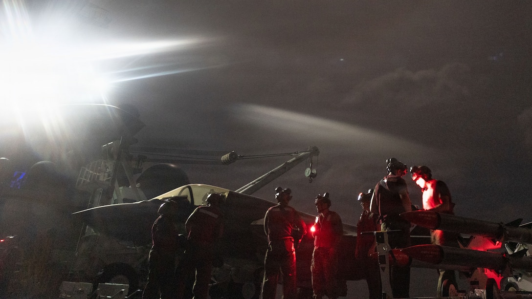U.S. Marines with Marine Fighter Attack Squadron (VMFA) 242, 31st Marine Expeditionary Unit, prepare to load ordinance onto an F-35B Lightning II aboard the forward-deployed amphibious assault carrier USS Tripoli (LHA 7), flagship of the Tripoli Expeditionary Strike Group, Dec. 7, 2025, while conducting routine operations in the U.S. 7th Fleet Area of Operations. The 31st MEU, the Marine Corps’ only continuously forward-deployed MEU, provides a flexible and lethal force ready to perform a wide range of military operations as the premiere crisis response force in the Indo-Pacific region. (U.S. Marine Corps photo by Lance Cpl. Raul Sotovilla)