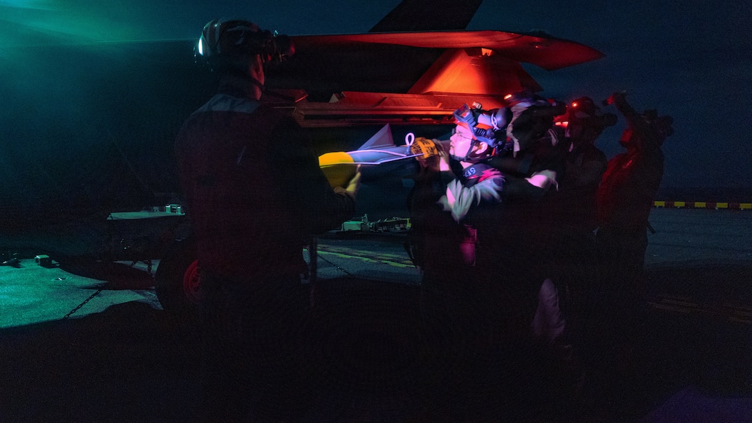 U.S. Marines with Marine Fighter Attack Squadron (VMFA) 242, 31st Marine Expeditionary Unit, prepare to load ordinance onto an F-35B Lightning II aboard the forward-deployed amphibious assault carrier USS Tripoli (LHA 7), flagship of the Tripoli Expeditionary Strike Group, Dec. 7, 2025, while conducting routine operations in the U.S. 7th Fleet Area of Operations. The 31st MEU, the Marine Corps’ only continuously forward-deployed MEU, provides a flexible and lethal force ready to perform a wide range of military operations as the premiere crisis response force in the Indo-Pacific region. (U.S. Marine Corps photo by Lance Cpl. Raul Sotovilla)