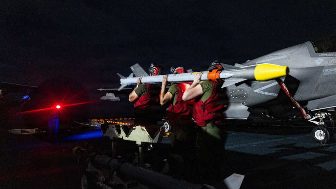 U.S. Marines with Marine Fighter Attack Squadron (VMFA) 242, 31st Marine Expeditionary Unit, prepare to load ordinance onto an F-35B Lightning II aboard the forward-deployed amphibious assault carrier USS Tripoli (LHA 7), flagship of the Tripoli Expeditionary Strike Group, Dec. 7, 2025, while conducting routine operations in the U.S. 7th Fleet Area of Operations. The 31st MEU, the Marine Corps’ only continuously forward-deployed MEU, provides a flexible and lethal force ready to perform a wide range of military operations as the premiere crisis response force in the Indo-Pacific region. (U.S. Marine Corps photo by Lance Cpl. Raul Sotovilla)