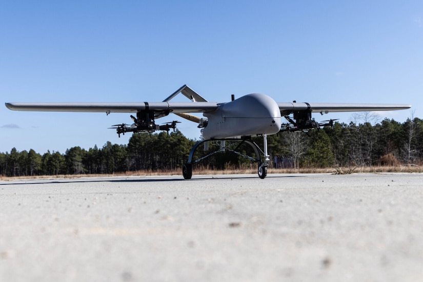 A military drone sits on a runway.