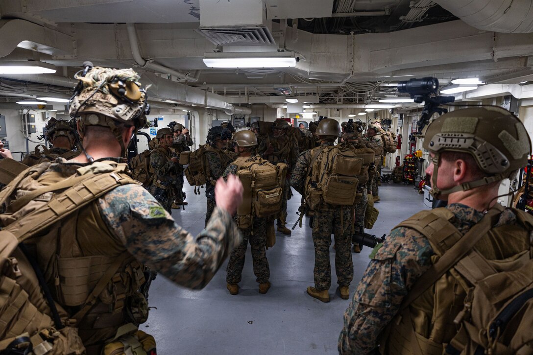 U.S. Marines with Weapons Company, Battalion Landing Team 3rd Battalion, 1st Marine Regiment, 31st Marine Expeditionary Unit, conduct gear checks aboard the forward-deployed amphibious assault carrier USS Tripoli (LHA 7), flagship of the Tripoli Expeditionary Strike Group, Dec. 3, 2025, while conducting routine operations in the U.S. 7th Fleet Area of Operations. Marines conducted call away drills in order to sustain mission capabilities in support of the 31st MEU. The 31st MEU, the Marine Corps’ only continuously forward-deployed MEU, provides a flexible and lethal force ready to perform a wide range of military operations as the premiere crisis response force in the Indo-Pacific region. (U.S. Marine Corps photo by Lance Cpl. Raul Sotovilla)