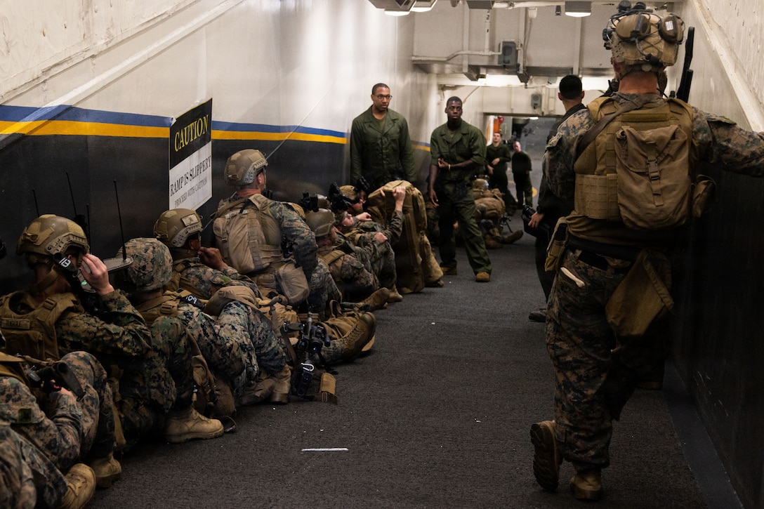 U.S. Marines with Weapons Company, Battalion Landing Team 3rd Battalion, 1st Marine Regiment, 31st Marine Expeditionary Unit, stage by the flight ramp aboard the forward-deployed amphibious assault carrier USS Tripoli (LHA 7), flagship of the Tripoli Expeditionary Strike Group, Dec. 3, 2025, while conducting routine operations in the U.S. 7th Fleet Area of Operations. Marines conducted call away drills in order to sustain mission capabilities in support of the 31st MEU. The 31st MEU, the Marine Corps’ only continuously forward-deployed MEU, provides a flexible and lethal force ready to perform a wide range of military operations as the premiere crisis response force in the Indo-Pacific region. (U.S. Marine Corps photo by Lance Cpl. Raul Sotovilla)