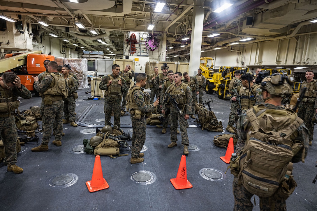 U.S. Marines with Weapons Company, Battalion Landing Team 3rd Battalion, 1st Marine Regiment, 31st Marine Expeditionary Unit, stage by the flight ramp aboard the forward-deployed amphibious assault carrier USS Tripoli (LHA 7), flagship of the Tripoli Expeditionary Strike Group, Dec. 3, 2025, while conducting routine operations in the U.S. 7th Fleet Area of Operations. Marines conducted call away drills in order to sustain mission capabilities in support of the 31st MEU. The 31st MEU, the Marine Corps’ only continuously forward-deployed MEU, provides a flexible and lethal force ready to perform a wide range of military operations as the premiere crisis response force in the Indo-Pacific region. (U.S. Marine Corps photo by Lance Cpl. Raul Sotovilla)