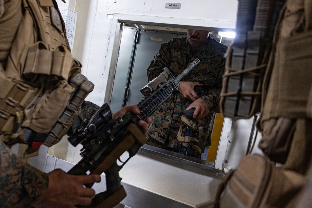 A U.S. Marine with Weapons Company, Battalion Landing Team 3rd Battalion, 1st Marine Regiment, 31st Marine Expeditionary Unit, draws an M4 Carbine from the armory aboard the forward-deployed amphibious assault carrier USS Tripoli (LHA 7), flagship of the Tripoli Expeditionary Strike Group, Dec. 3, 2025, while conducting routine operations in the U.S. 7th Fleet Area of Operations. The 31st MEU, the Marine Corps’ only continuously forward-deployed MEU, provides a flexible and lethal force ready to perform a wide range of military operations as the premiere crisis response force in the Indo-Pacific region. (U.S. Marine Corps photo by Lance Cpl. Raul Sotovilla)