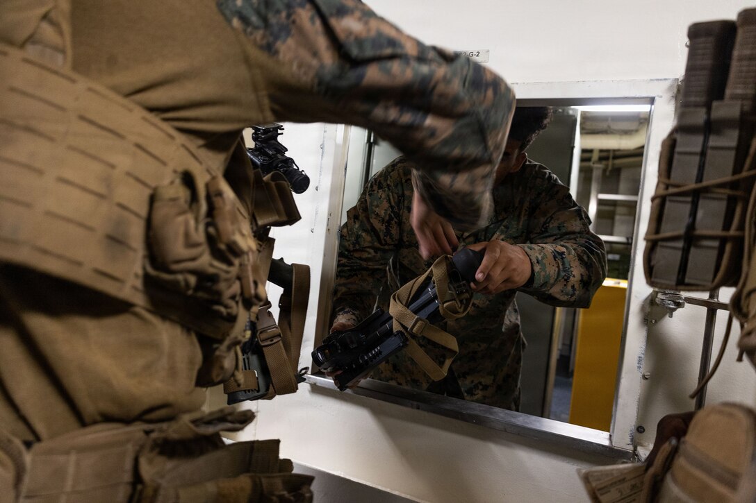 A U.S. Marine with Weapons Company, Battalion Landing Team 3rd Battalion, 1st Marine Regiment, 31st Marine Expeditionary Unit, draws a P320 grenade launcher from the armory aboard the forward-deployed amphibious assault carrier USS Tripoli (LHA 7), flagship of the Tripoli Expeditionary Strike Group, Dec. 3, 2025, while conducting routine operations in the U.S. 7th Fleet Area of Operations. Marines conducted call away drills in order to sustain mission capabilities in support of the 31st MEU. The 31st MEU, the Marine Corps’ only continuously forward-deployed MEU, provides a flexible and lethal force ready to perform a wide range of military operations as the premiere crisis response force in the Indo-Pacific region. (U.S. Marine Corps photo by Lance Cpl. Raul Sotovilla)