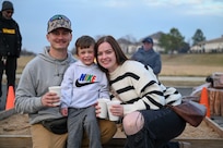 U.S. Air Force Tech. Sgt. Trenton Ballard, his wife, U.S. Air Force Tech. Sgt. Erika Ballard, and their son, Carson, pose for a family photo at Winterfest on Joint Base Anacostia-Bolling, Washington, D.C., Dec. 6, 2025. The event featured a boat parade, various vendors, a bonfire, Santa Claus and a holiday light display. (U.S. Air Force photo by Airman 1st Class Shanel Toussaint)