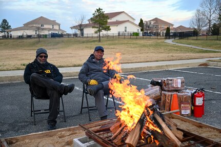 Tyrone Harding, left, a mechanic at the Potomac Lanes Bowling Center, and Audie Douglas, recreational center aide, gather by the bonfire during the Winterfest celebration at Joint Base Anacostia-Bolling, Washington, D.C., Dec. 6, 2025. The event featured a boat parade, various vendors, a bonfire, Santa Claus and a holiday light display. (U.S. Air Force photo by Airman 1st Class Shanel Toussaint)
