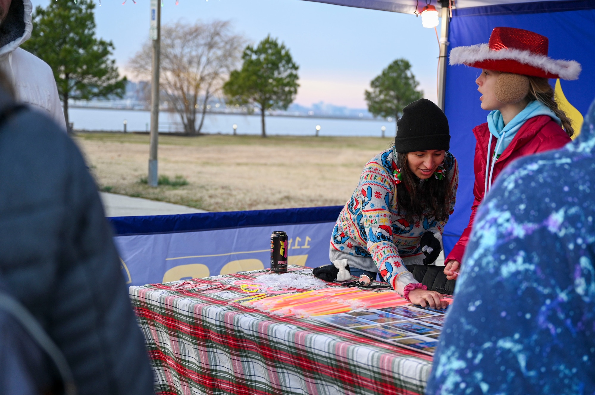 Jaylee Schmidt, 811th Force Support Squadron marketing coordinator, speaks with a military family during the Winterfest celebration at Joint Base Anacostia-Bolling, Washington, D.C., Dec. 6, 2025. The 811th FSS hosted the event in support of their mission to provide family support to Airmen in the National Capital Region. (U.S. Air Force photo by Airman 1st Class Shanel Toussaint)