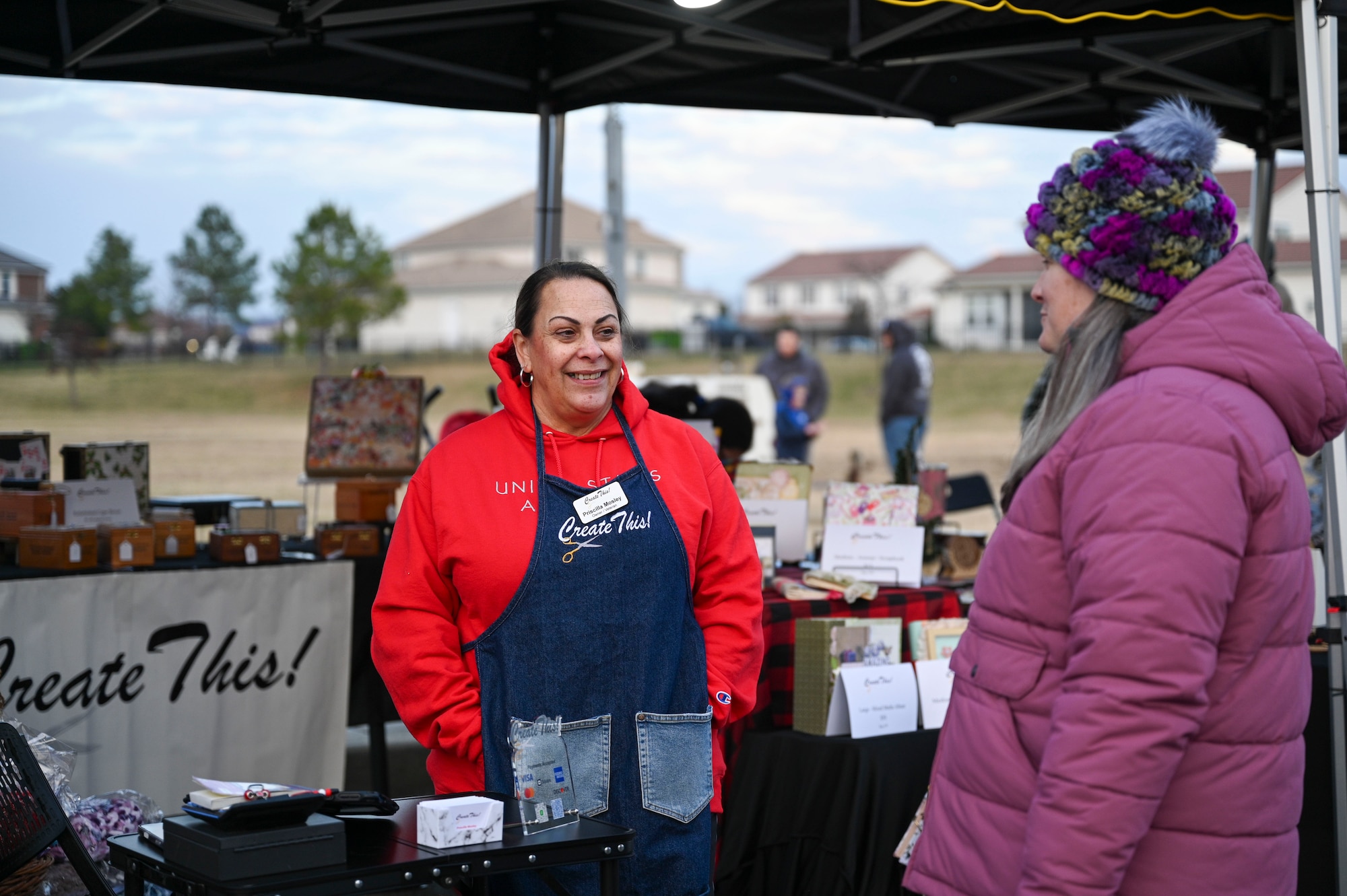 Retired U.S. Air Force Master Sgt. Priscilla Mosley, left, owner of local business Create This, speaks with an attendee during the Winterfest celebration at Joint Base Anacostia-Bolling, Washington, D.C., Dec. 6, 2025. The 811th FSS hosted the event in support of their mission to provide family support to Airmen in the National Capital Region. (U.S. Air Force photo by Airman 1st Class Shanel Toussaint)
