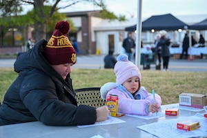 McKayla Kerr, left, and her daughter, Elizabeth, color together during the Winterfest celebration at Joint Base Anacostia-Bolling, Washington, D.C., Dec. 6, 2025. The event featured a boat parade, various vendors, a bonfire, Santa Claus and a holiday light display. (U.S. Air Force photo by Airman 1st Class Shanel Toussaint)