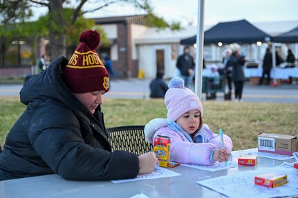 McKayla Kerr, left, and her daughter, Elizabeth, color together during the Winterfest celebration at Joint Base Anacostia-Bolling, Washington, D.C., Dec. 6, 2025. The event featured a boat parade, various vendors, a bonfire, Santa Claus and a holiday light display. (U.S. Air Force photo by Airman 1st Class Shanel Toussaint)