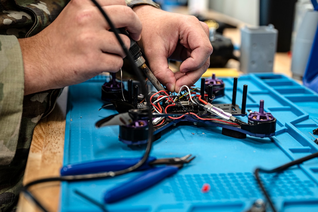U.S. Air Force Airman 1st Class Kelson Whitten, 9th Air Force (Air Forces Central) Battle Lab software engineer, solders wires on a drone chassis Nov. 7, 2025, at Shaw Air Force Base, South Carolina. The AFCENT Battle Lab is constructing small, unmanned aircraft systems to be used in a variety of applications throughout the U.S. Central Command area of responsibility. (U.S. Air Force photo by Tech. Sgt. Aaron J. Jenne)
