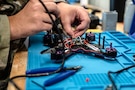 U.S. Air Force Airman 1st Class Kelson Whitten, 9th Air Force (Air Forces Central) Battle Lab software engineer, solders wires on a drone chassis Nov. 7, 2025, at Shaw Air Force Base, South Carolina. The AFCENT Battle Lab is constructing small, unmanned aircraft systems to be used in a variety of applications throughout the U.S. Central Command area of responsibility. (U.S. Air Force photo by Tech. Sgt. Aaron J. Jenne)
