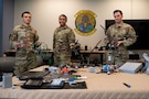 U.S. Air Force Airman 1st Class Kelson Whitten, Airman 1st Class Keelam Graham and Airman 1st Class Braden Schwartz, 9th Air Force (Air Forces Central) Battle Lab software engineers, display several drone systems Nov. 7, 2025, at Shaw Air Force Base, South Carolina. The AFCENT Battle Lab is constructing small, unmanned aircraft systems to be used in a variety of applications throughout the U.S. Central Command area of responsibility. (U.S. Air Force photo by Tech. Sgt. Aaron J. Jenne)