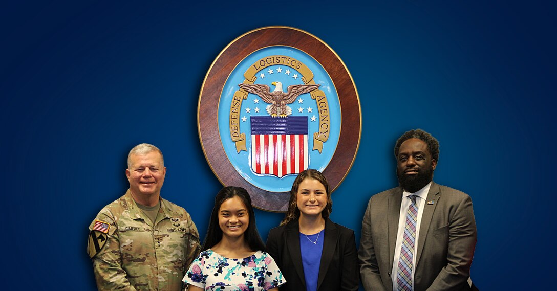 Four people are standing in front of a blue background with the Agency seal shown.