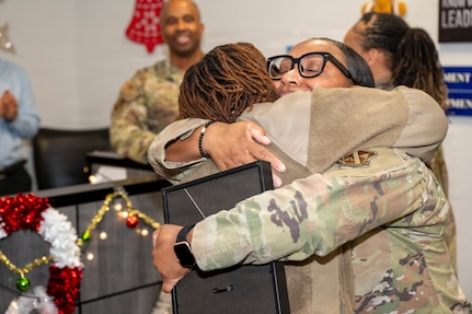 U.S. Air Force Tech. Sgt. Tomarra Woods, right, the noncommissioned officer in charge of outbound assignments, hugs Staff. Sgt. Samantha Gordon, the section chief of customer support, both with the 11th Military Personnel Flight, during Woods’ promotion ceremony on Joint Base Anacostia-Bolling, Washington, D.C., Nov. 25, 2025. Woods received the Stripes for Exceptional Performers promotion for her outstanding performance as an NCO at the 11th MPF. (U.S. Air Force photo by Hayden Hallman)