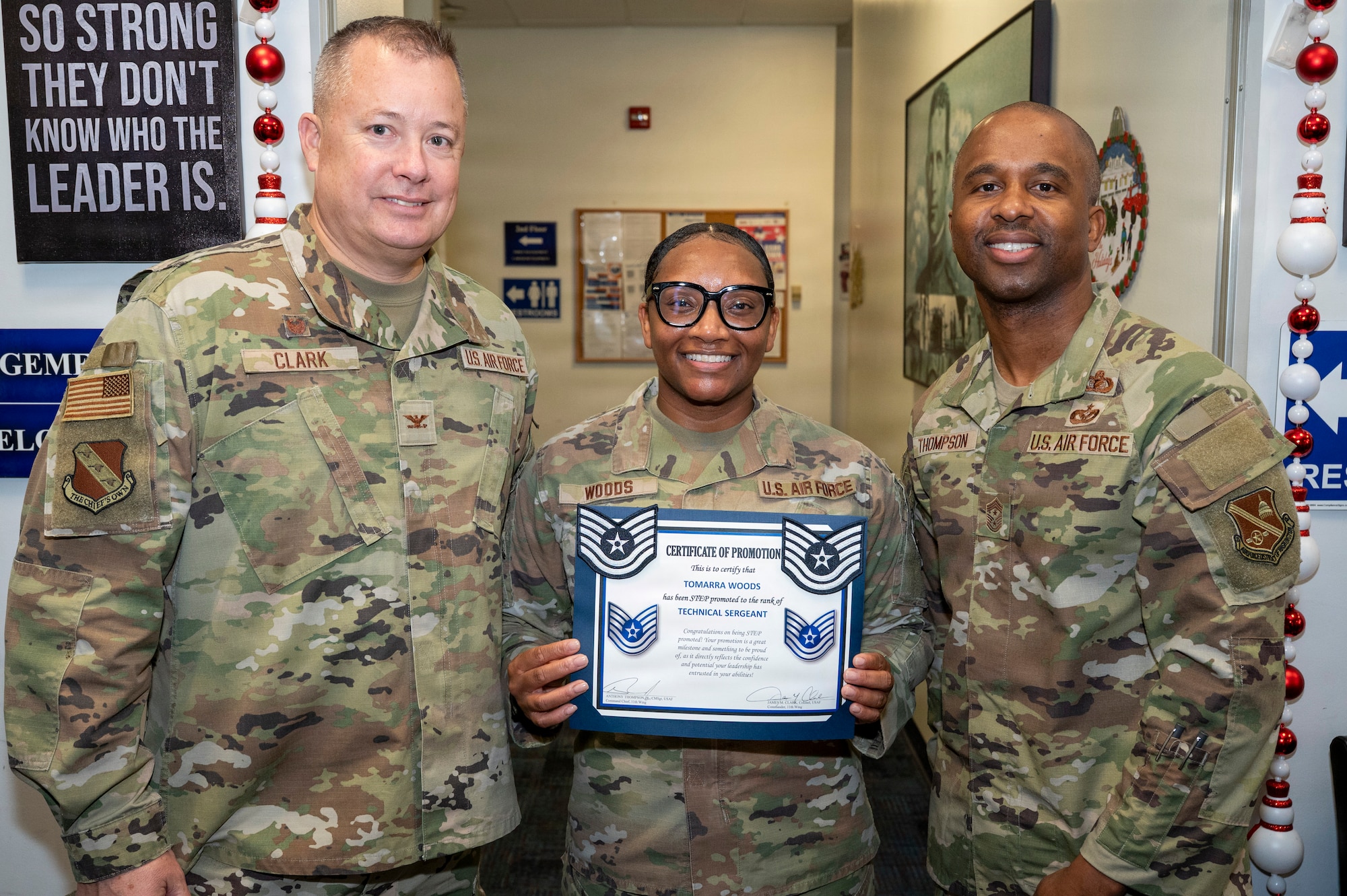 From left, U.S. Air Force Col. James M. Clark, commander of Joint Base Anacostia-Bolling and the 11th Wing, Tech. Sgt. Tomarra Woods, the noncommissioned officer in charge of outbound assignments with the 11th Military Personnel Flight, and Chief Master Sgt. Anthony Thompson Jr., senior enlisted leader for JBAB and 11th Wing command chief, gather for a photo during Woods’ promotion ceremony on Joint Base Anacostia-Bolling, Washington, D.C., Nov. 25, 2025. Woods received the Stripes for Exceptional Performers promotion for her outstanding performance as an NCO at the 11th MPF. (U.S. Air Force photo by Hayden Hallman)