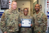 From left, U.S. Air Force Col. James M. Clark, commander of Joint Base Anacostia-Bolling and the 11th Wing, Tech. Sgt. Tomarra Woods, the noncommissioned officer in charge of outbound assignments with the 11th Military Personnel Flight, and Chief Master Sgt. Anthony Thompson Jr., senior enlisted leader for JBAB and 11th Wing command chief, gather for a photo during Woods’ promotion ceremony on Joint Base Anacostia-Bolling, Washington, D.C., Nov. 25, 2025. Woods received the Stripes for Exceptional Performers promotion for her outstanding performance as an NCO at the 11th MPF. (U.S. Air Force photo by Hayden Hallman)