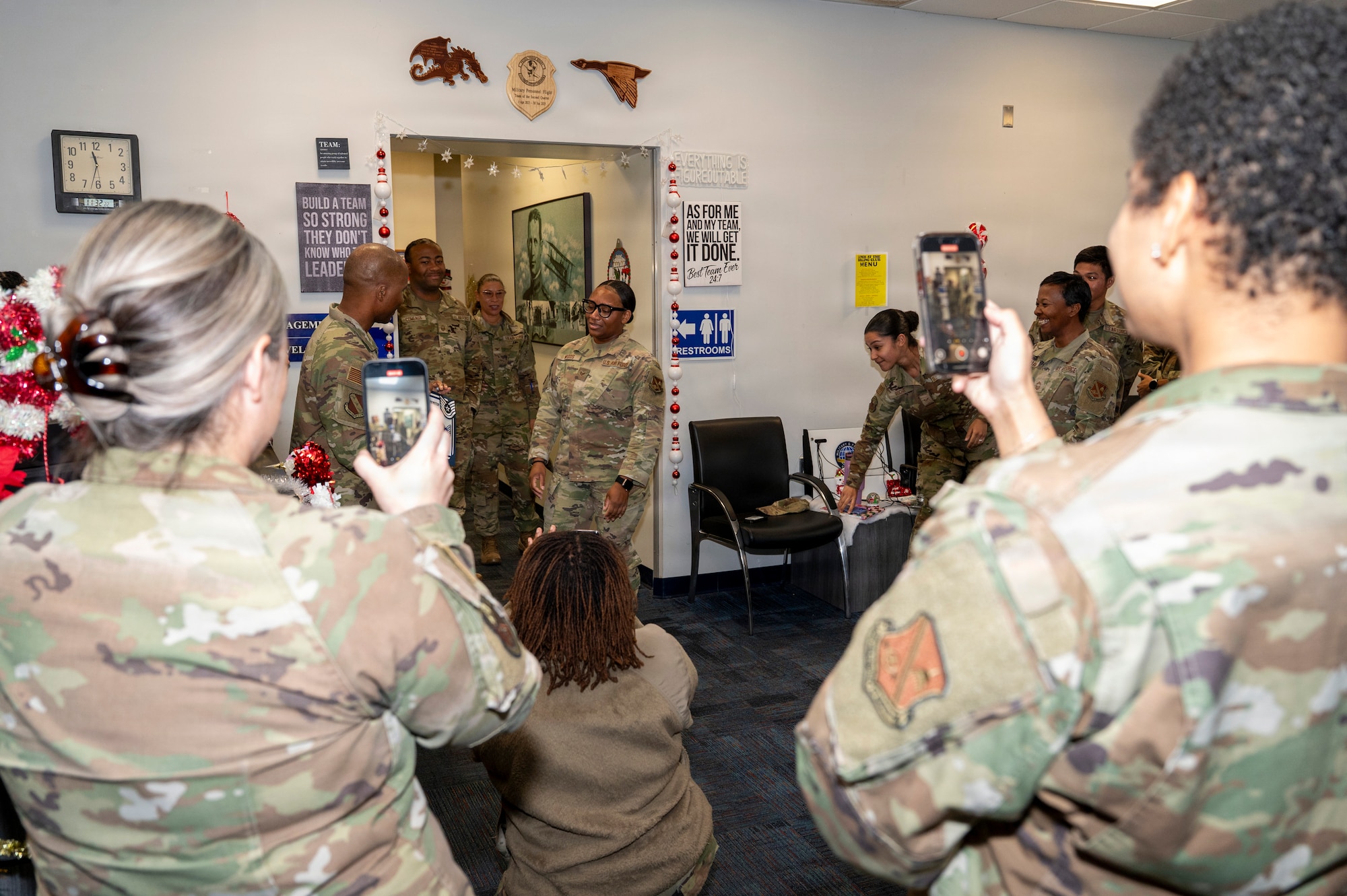 U.S. Air Force Chief Master Sgt. Anthony Thompson Jr., center left, senior enlisted leader for Joint Base Anacostia-Bolling and 11th Wing command chief, congratulates Tech. Sgt. Tomarra Woods, center right, the noncommissioned officer in charge of outbound assignments with the 11th Military Personnel Flight, as members of the 11th MPF watch during Woods’ promotion ceremony on JBAB, Washington, D.C., Nov. 25, 2025. Woods attained the rank of technical sergeant through the Stripes for Exceptional Performers program that rewards outstanding Airmen for exceptional performance with a special and limited promotion to the ranks of staff sergeant, technical sergeant or master sergeant. (U.S. Air Force photo by Hayden Hallman)
