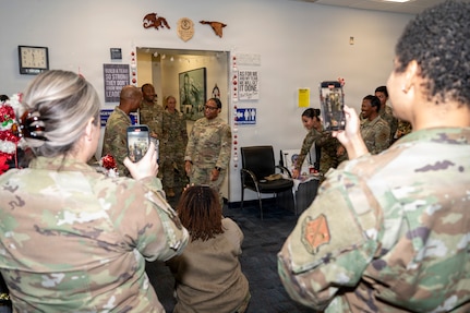 U.S. Air Force Chief Master Sgt. Anthony Thompson Jr., center left, senior enlisted leader for Joint Base Anacostia-Bolling and 11th Wing command chief, congratulates Tech. Sgt. Tomarra Woods, center right, the noncommissioned officer in charge of outbound assignments with the 11th Military Personnel Flight, as members of the 11th MPF watch during Woods’ promotion ceremony on JBAB, Washington, D.C., Nov. 25, 2025. Woods attained the rank of technical sergeant through the Stripes for Exceptional Performers program that rewards outstanding Airmen for exceptional performance with a special and limited promotion to the ranks of staff sergeant, technical sergeant or master sergeant. (U.S. Air Force photo by Hayden Hallman)